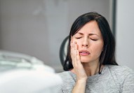 Patient with toothache sitting in treatment chair