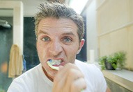 Man brushes teeth