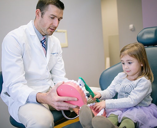 Dr. Springhetti teaching young patient to brush teeth