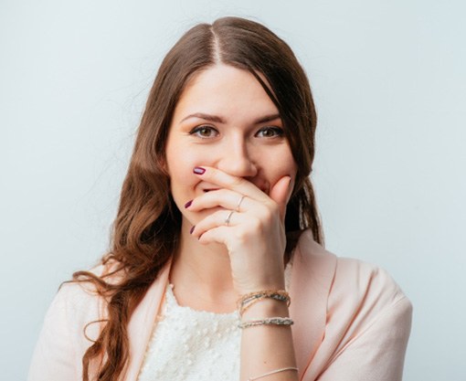 a woman covering up her smile