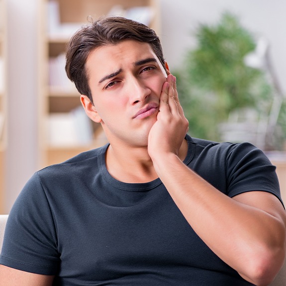 Man in pain holding jaw