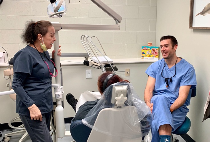 Dr. Springhetti and team member talking to dental patient