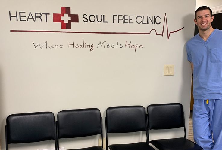 Dr. Springhetti standing next to Heart and Sould Free Clinic sign