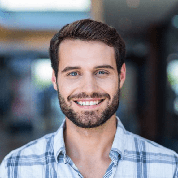 a man smiling after receiving his dental crown