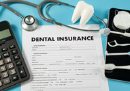insurance form next to calculator and dental instruments