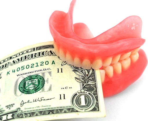 Denture biting down on a dollar bill