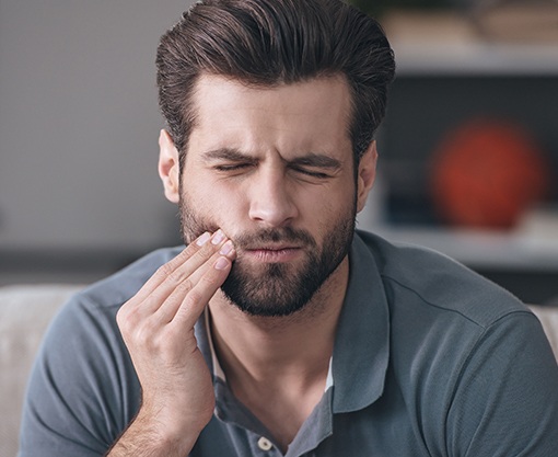 Man in pain holding cheek