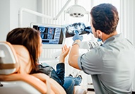 Dentist discussing x-rays with patient in dental chair