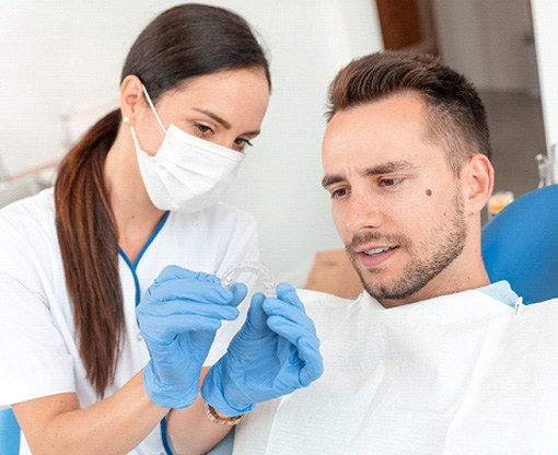 A dentist showing her patient Invisalign aligners