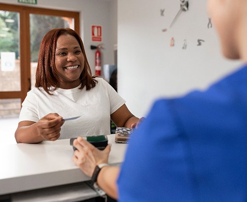 A woman paying for dental care
