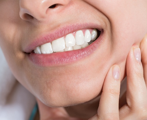 Closeup of patient grimacing and holding jaw