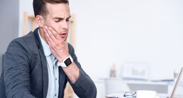 Man in pain holding jaw