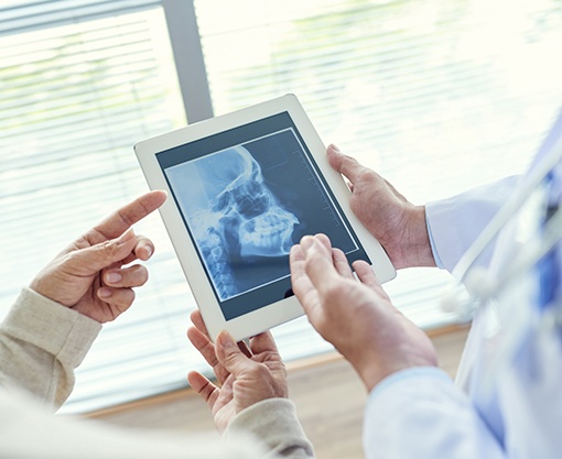 Dentist looking at x-rays of jaw and skull