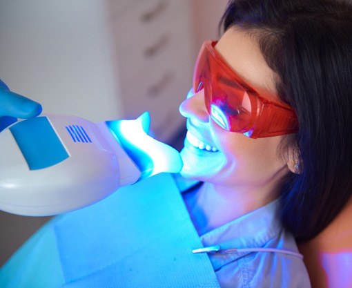 Woman in dental chair receiving in-office teeth whitening in Carmel, IN 