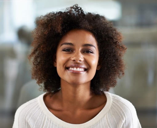 Woman wearing a white sweater and smiling 