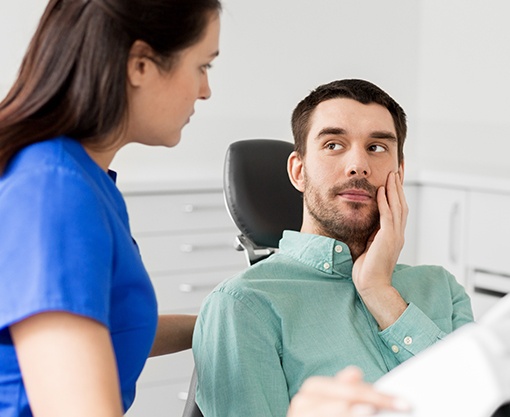 Man in pain holding jaw