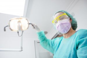 dentist in Carmel with personal protective equipment on treating a patient
