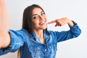 Woman Pointing to Smile