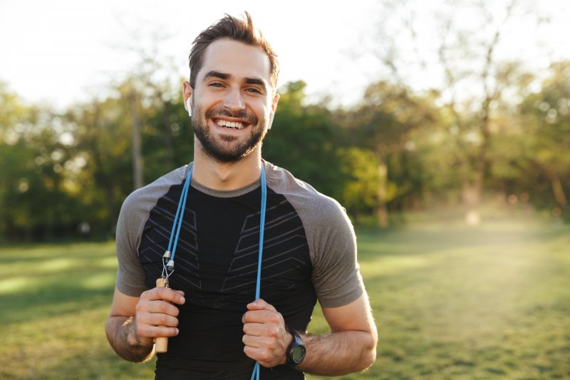 A physically fit man smiling outdoors