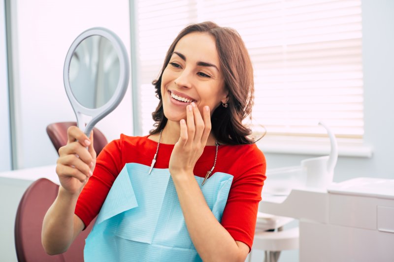 a woman in Carmel checking her new dental crown