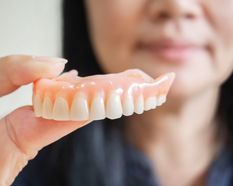 Woman holding dentures