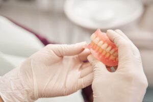 Dentist holding denture.