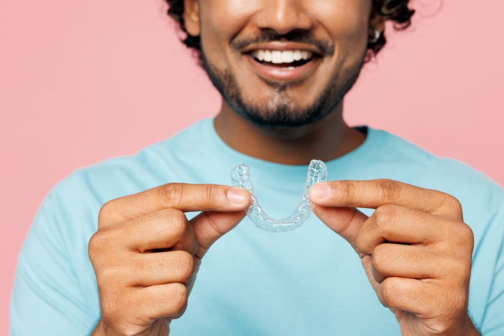 A man holding an Invisalign aligner