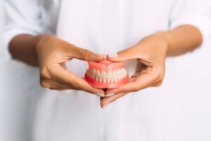 Person holding set of dentures.